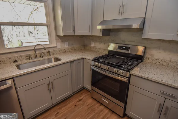 a kitchen with a sink stove and cabinets