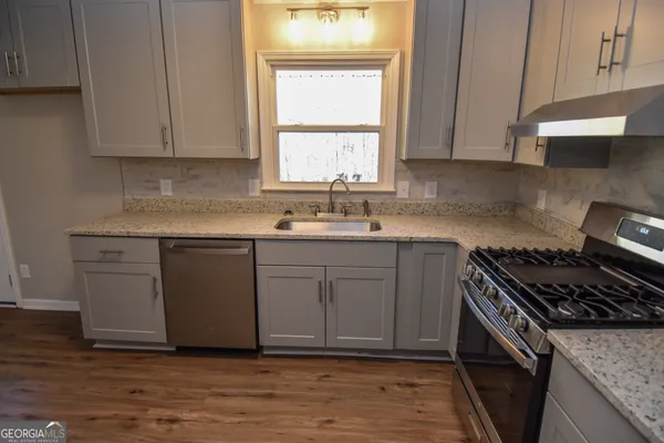a stove top oven sitting inside of a kitchen