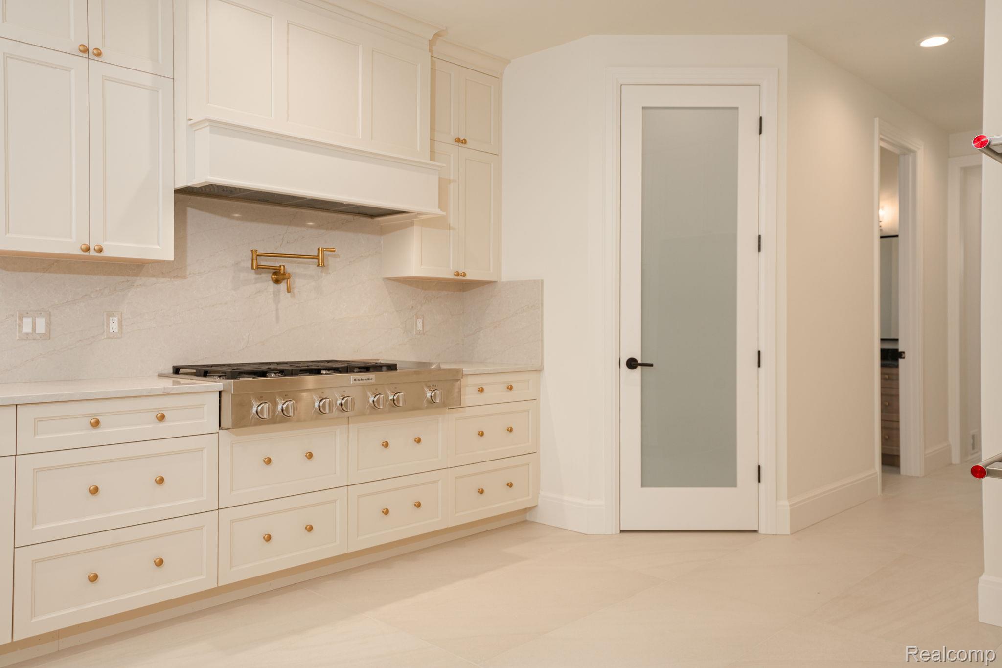 3836 Coachwood Lane Rochester, MI 48309 - Photo 39 of 82 Gourmet kitchen with white cabinetry, gold-tone hardware, and a stainless steel professional range