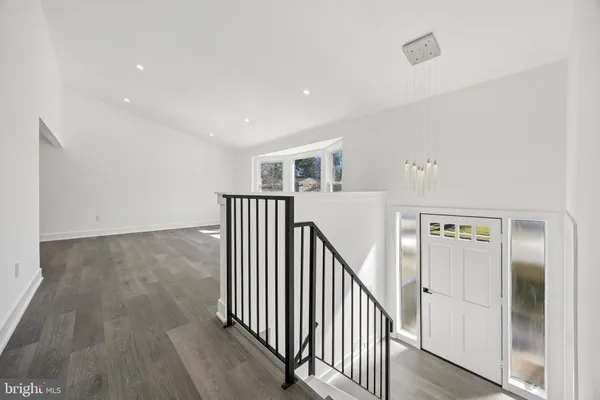 a view of a hallway with wooden floor and entryway