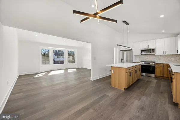 a large kitchen with cabinets wooden floor and stainless steel appliances