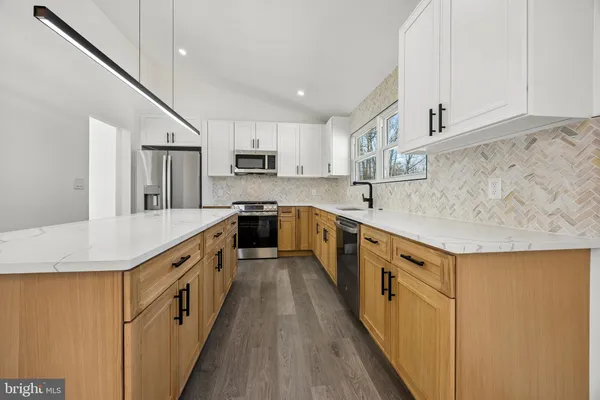 a large kitchen with stainless steel appliances sink a microwave and cabinets