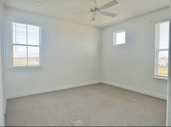 a bed sitting in a bedroom next to a window and a chandelier