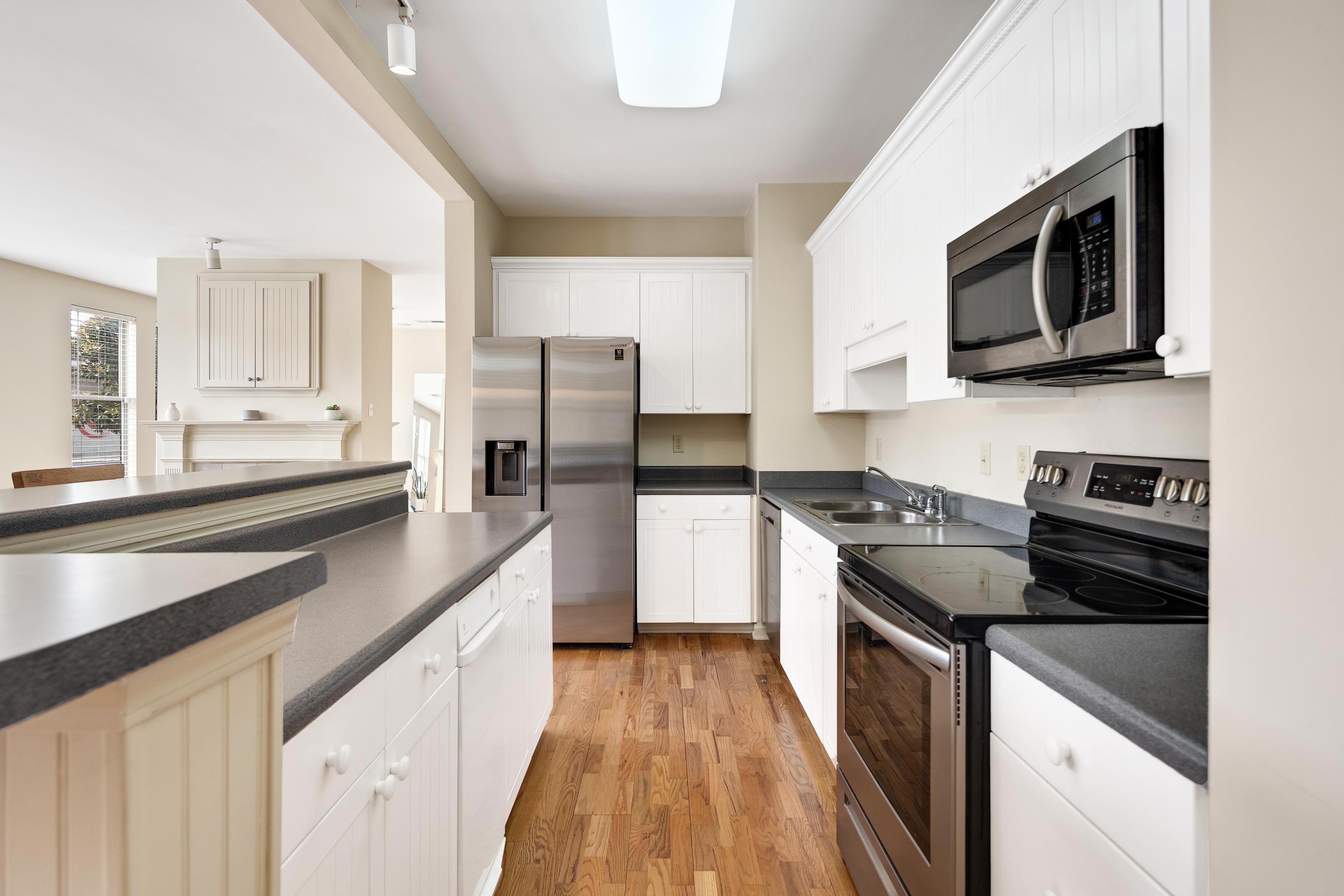 600 South Main Street, Unit 101 Memphis, TN 38103 - Photo 12 of 35 a kitchen with stainless steel appliances kitchen island granite countertop a stove a sink and a microwave