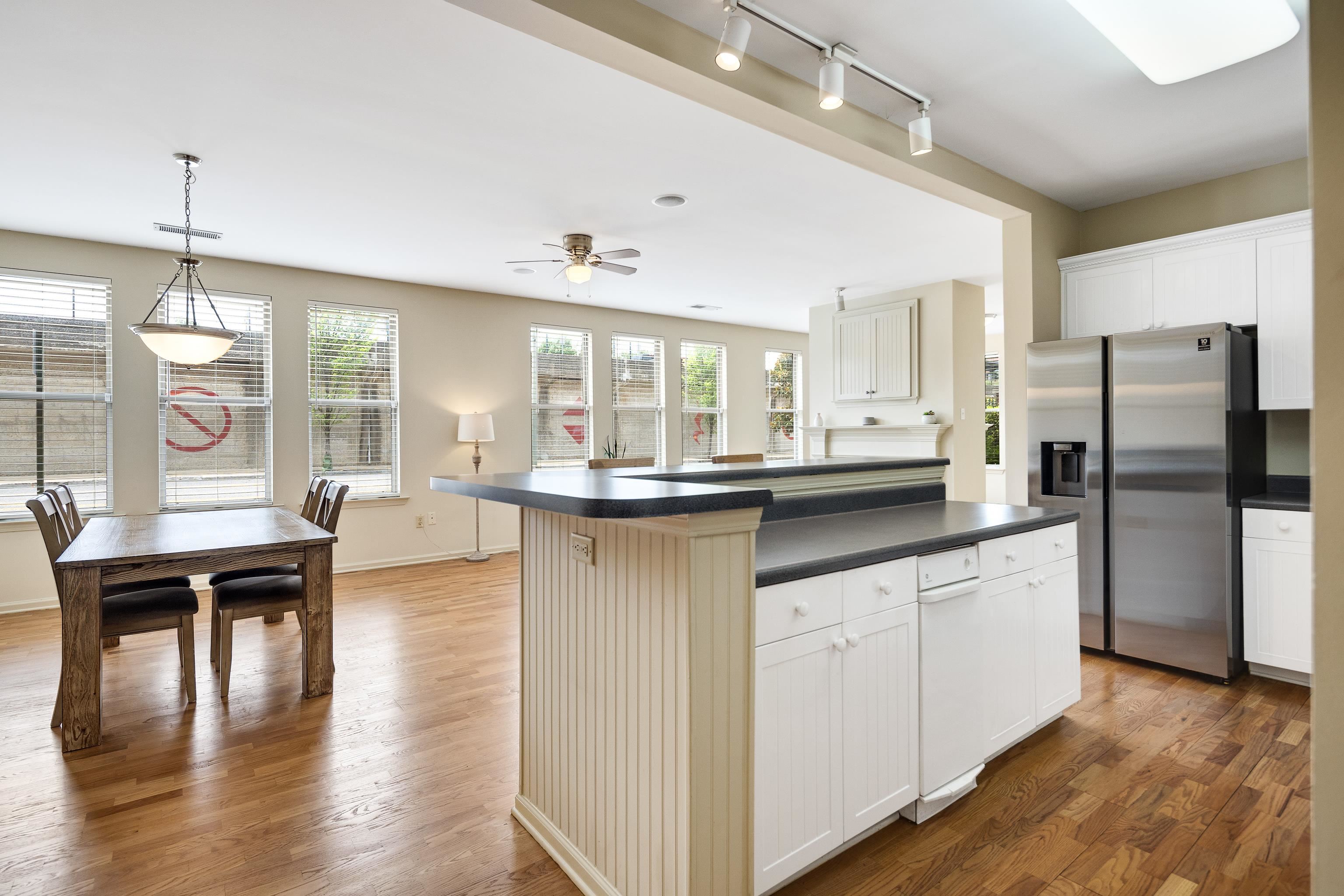 600 South Main Street, Unit 101 Memphis, TN 38103 - Photo 7 of 35 a kitchen with stainless steel appliances granite countertop a refrigerator a sink dishwasher a stove and a dining table with wooden floor
