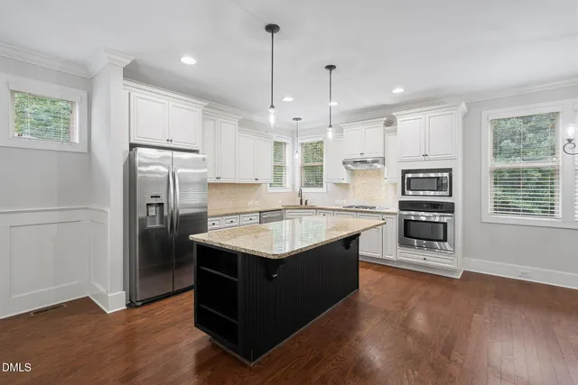 a bedroom with a bed and a dresser next to a window