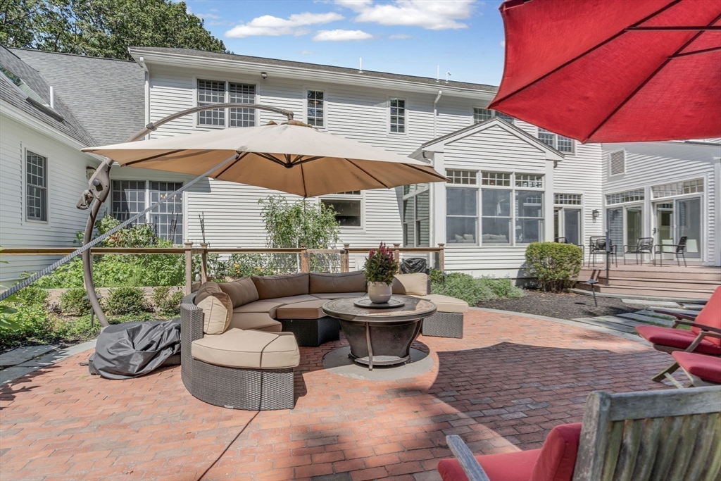 295 Musterfield Road Concord, MA 01742 - Photo 38 of 40 a patio with couches table and chairs under an umbrella