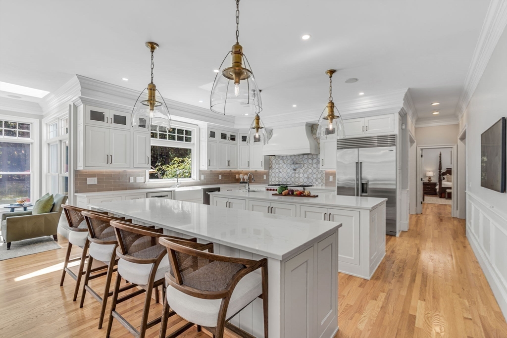 295 Musterfield Road Concord, MA 01742 - Photo 7 of 40 a view of a kitchen with kitchen island stainless steel appliances a stove a sink a center island and a wooden floor