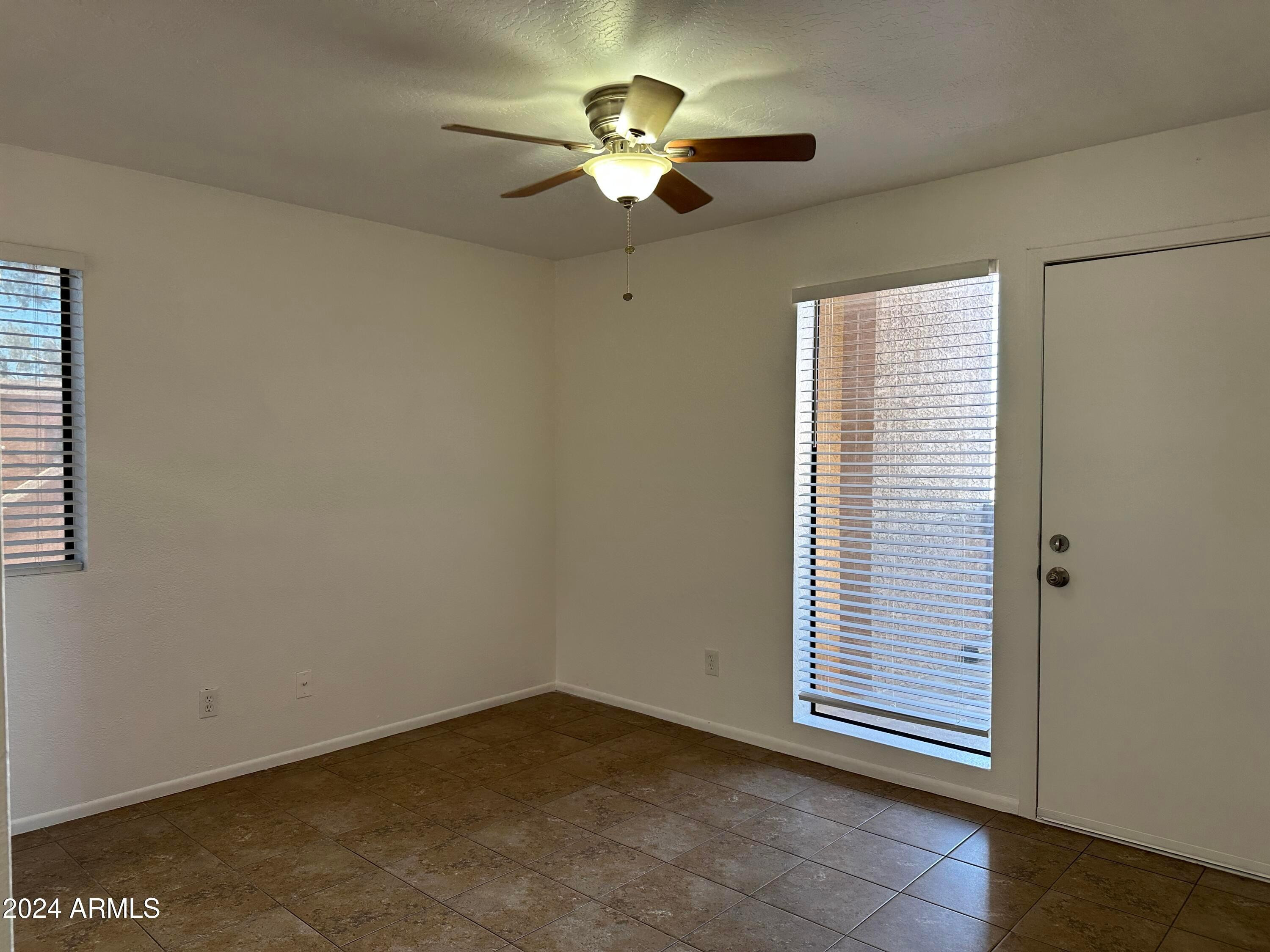 2650 East McKellips Road, Unit 204 Mesa, AZ 85213 - Photo 13 of 13 a view of an empty room with a ceiling fan and window