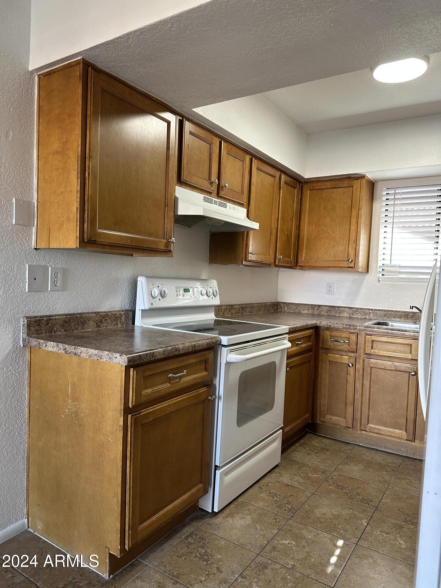 2650 East McKellips Road, Unit 204 Mesa, AZ 85213 - Photo 5 of 13 a kitchen with stainless steel appliances granite countertop a stove a sink and a microwave