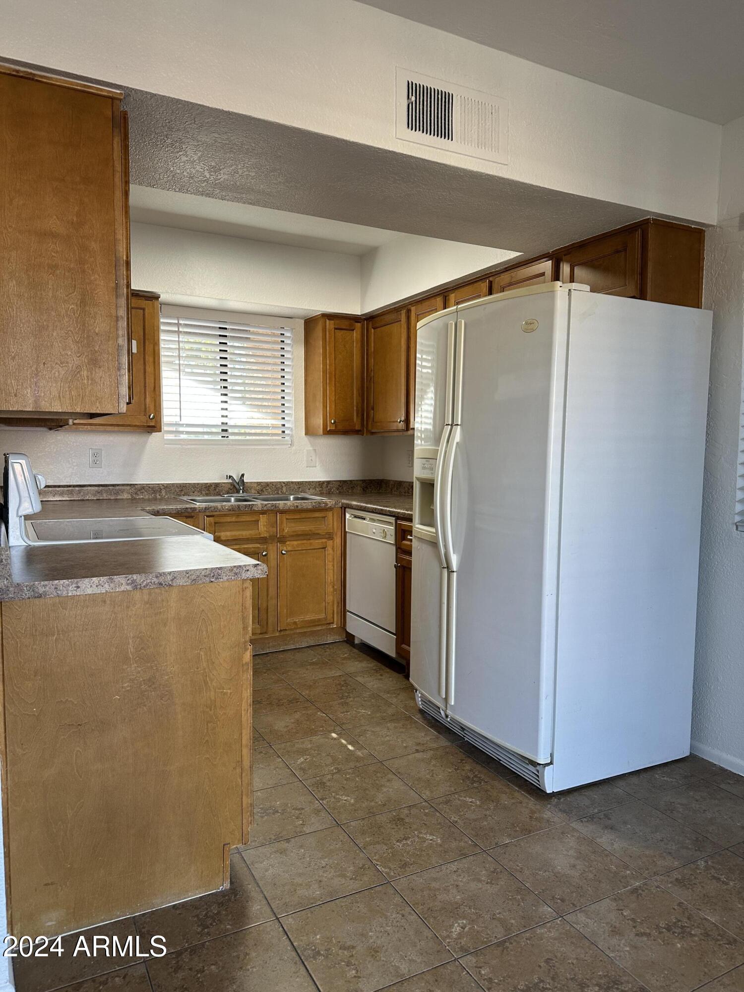 2650 East McKellips Road, Unit 204 Mesa, AZ 85213 - Photo 6 of 13 a kitchen with stainless steel appliances granite countertop a refrigerator and a sink