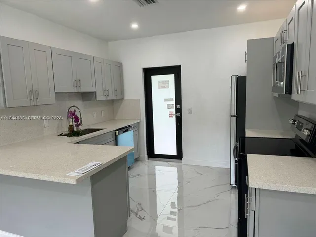 a kitchen with stainless steel appliances granite countertop a refrigerator and a sink