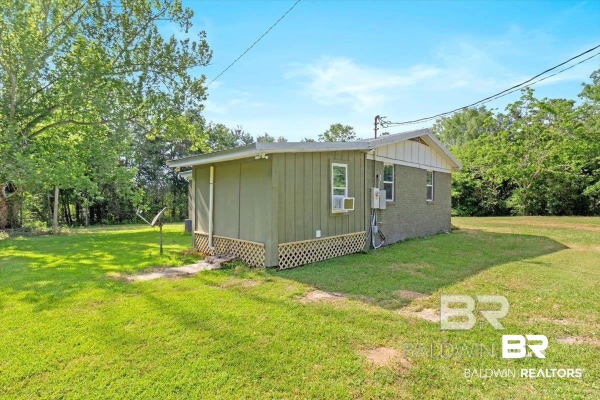 29397 Loper Road Loxley, AL 36551 - Photo 4 of 22 View of side of property featuring a yard, board and batten siding, and brick siding