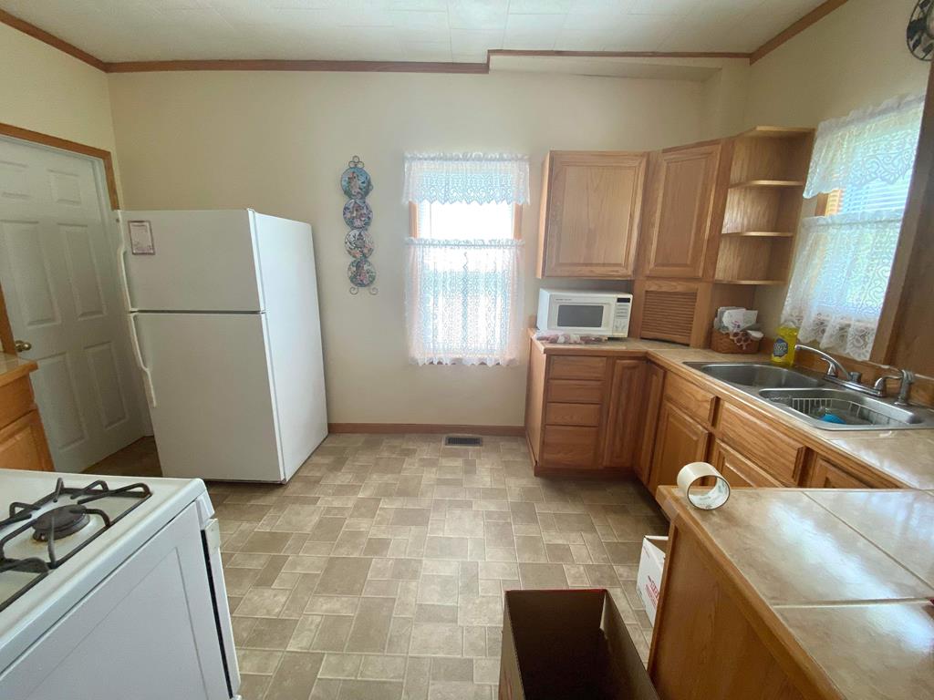 1007 Perryville Road Parker, PA 16049 - Photo 12 of 20 a view of a kitchen with fridge and wooden floor