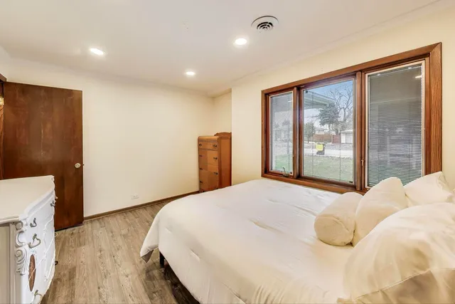 a bedroom with a bed and wooden floor