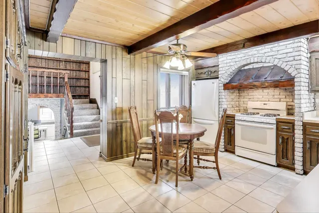 a dining room with stainless steel appliances kitchen island granite countertop a table chairs and granite counter tops