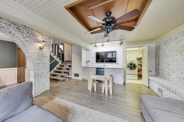 a view of a livingroom with wooden floor and a ceiling fan