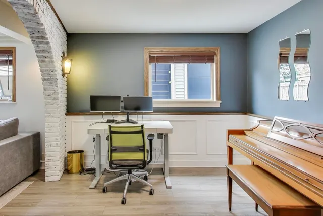a view of a workspace with furniture and a window