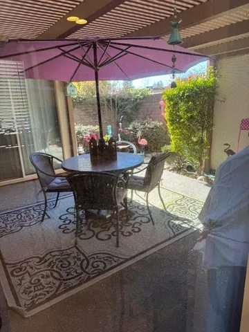 a view of a patio with table and chairs under an umbrella