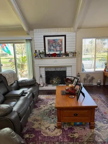 a living room with furniture a large window and a fireplace