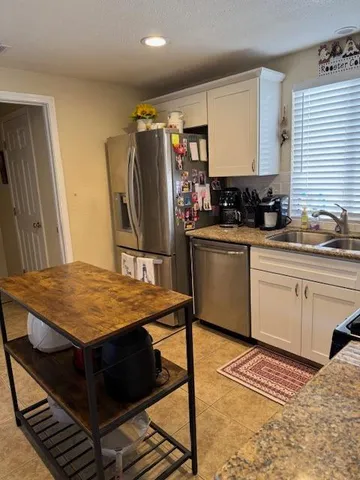 a kitchen with stainless steel appliances kitchen island granite countertop a sink stove and refrigerator