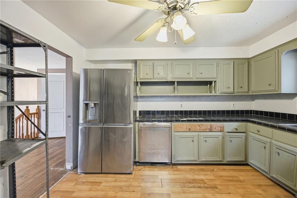 3801 Greenfield Road Allison Park, PA 15101 - Photo 16 of 39 a kitchen with stainless steel appliances granite countertop a refrigerator a sink dishwasher a stove and white cabinets with wooden floor