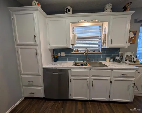 a kitchen with cabinets a sink and wooden floor