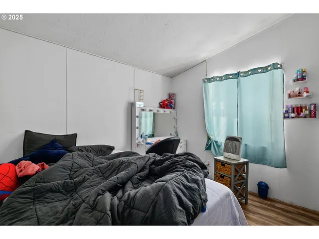 a bed sitting in a bedroom next to a window