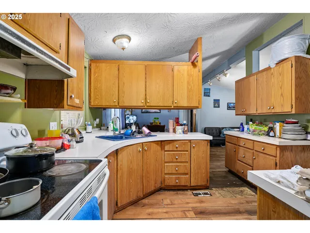 a kitchen with a sink appliances cabinets and a window