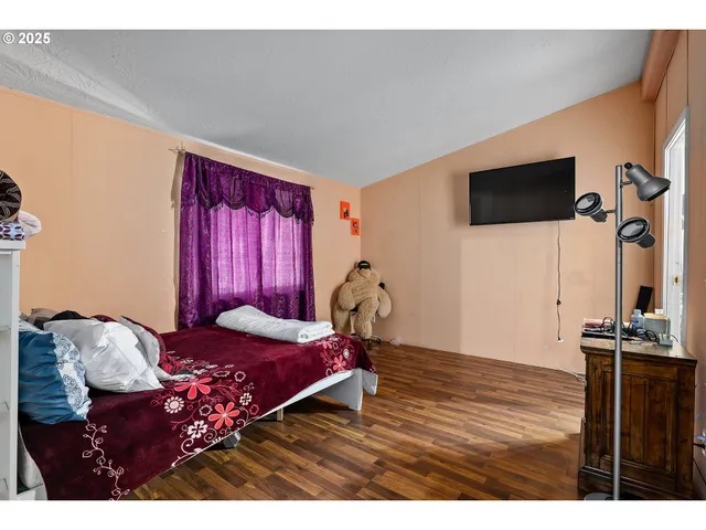 a bedroom with a bed window and a flat screen tv