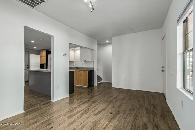 wooden floor in an empty room with a kitchen