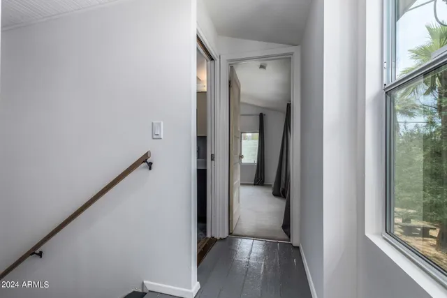 a view of a hallway with wooden floor and staircase