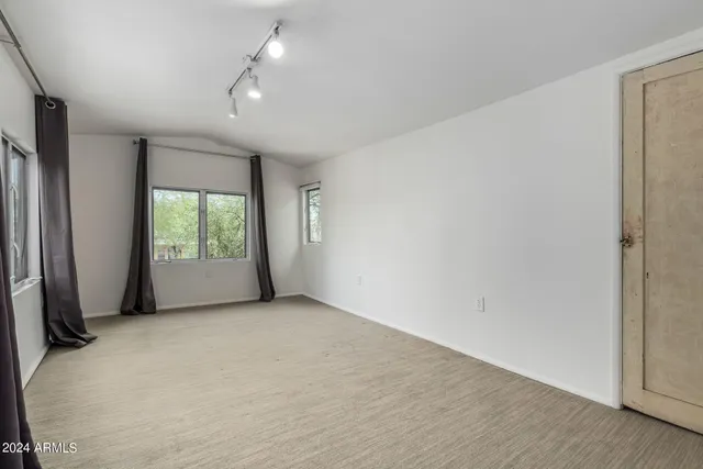 an empty room with windows and closet