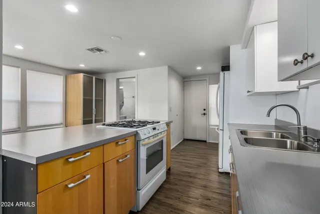 a kitchen with stainless steel appliances granite countertop a stove a sink and a refrigerator