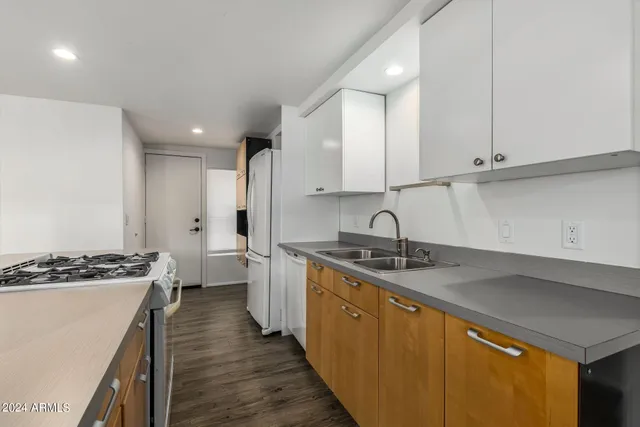 a kitchen with stainless steel appliances granite countertop a sink stove and cabinets