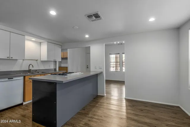 a kitchen with counter top space and wooden floor