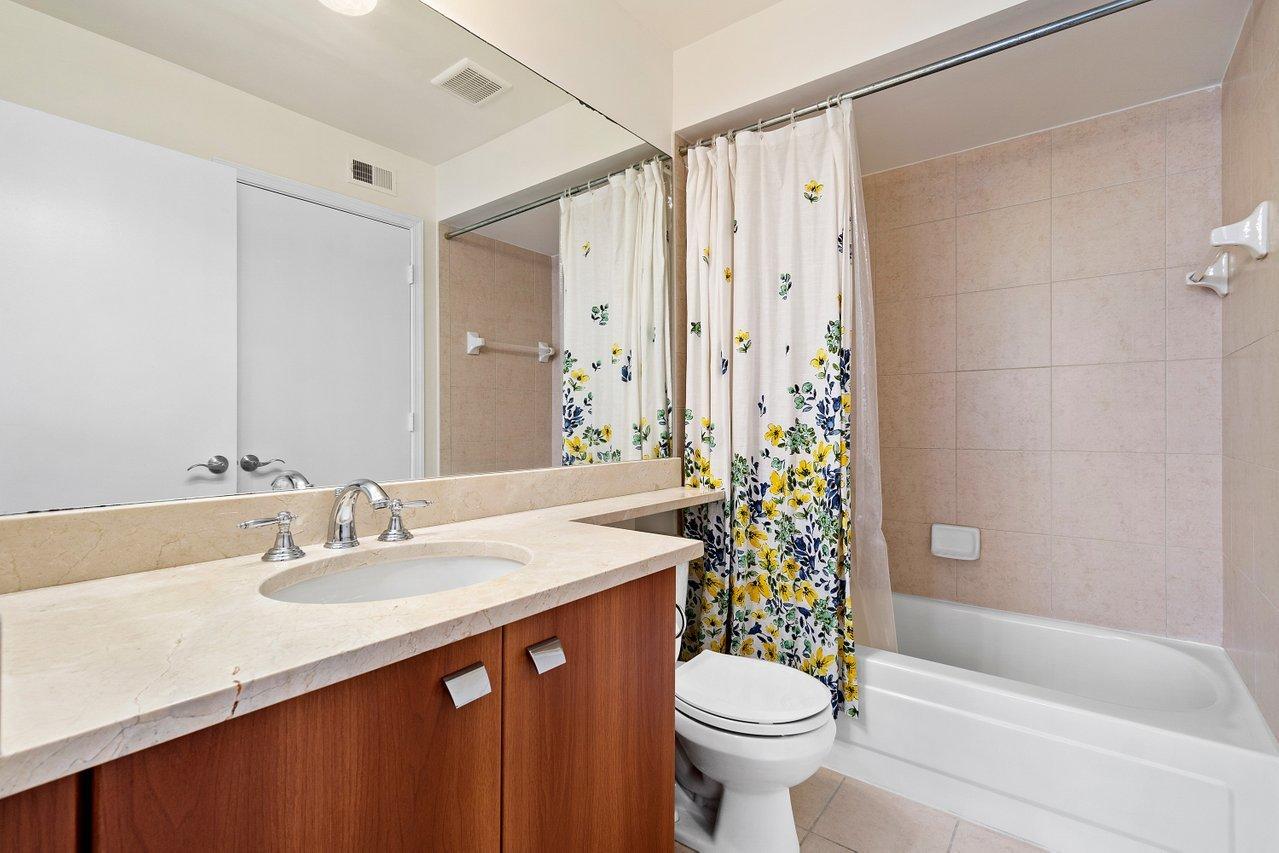 1275 Crystal Way, Unit B Delray Beach, FL 33444 - Photo 19 of 37 a bathroom with a sink a toilet a mirror a bathtub and shower