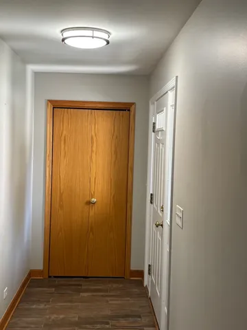 an empty room with wooden floor and closet area