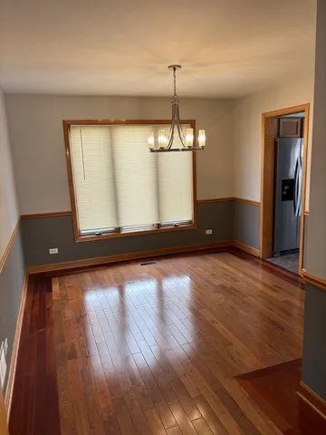 a view of a room with wooden floor staircase and a kitchen