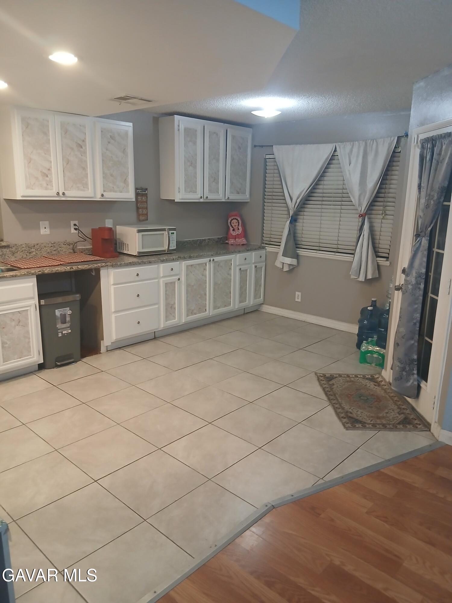 4111 Saddleback Road Palmdale, CA 93552 - Photo 10 of 23 a kitchen with granite countertop a sink cabinets and wooden floor