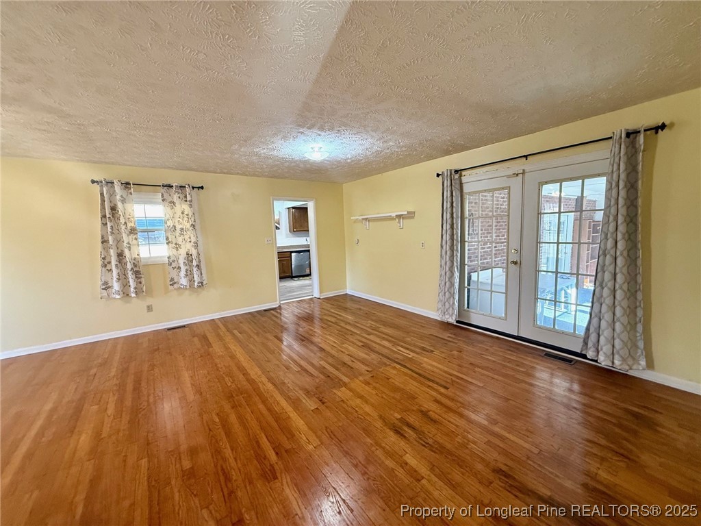741 Newport Road Fayetteville, NC 28314 - Photo 17 of 48 a view of empty room with wooden floor and fan
