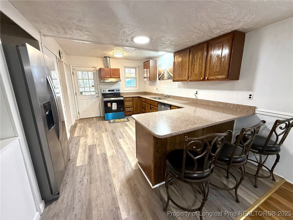 741 Newport Road Fayetteville, NC 28314 - Photo 20 of 48 a kitchen with a sink a stove and chairs