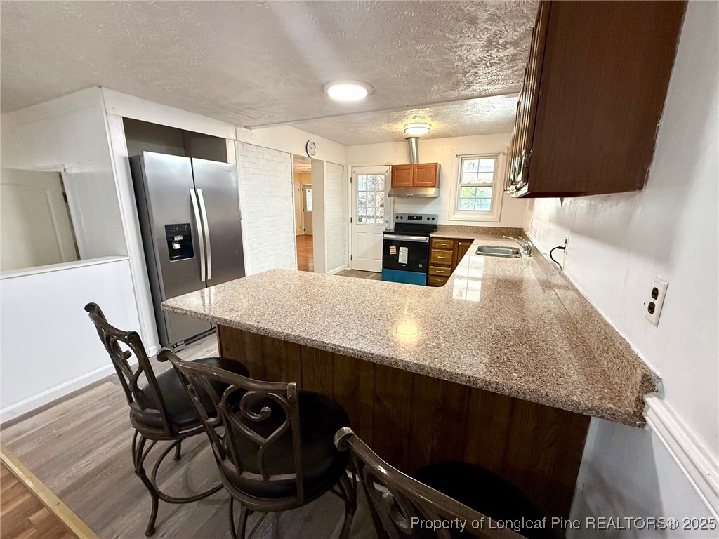 741 Newport Road Fayetteville, NC 28314 - Photo 21 of 48 a kitchen with stainless steel appliances a kitchen island a stove a table and chairs