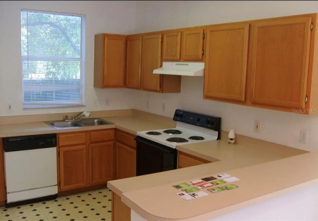 4415 Southwest 34th Street, Unit 708 Gainesville, FL 32608 - Photo 2 of 9 a kitchen with a sink a stove and wooden cabinets