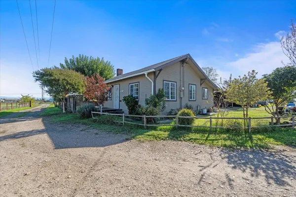 a view of a house with a big yard plants and trees