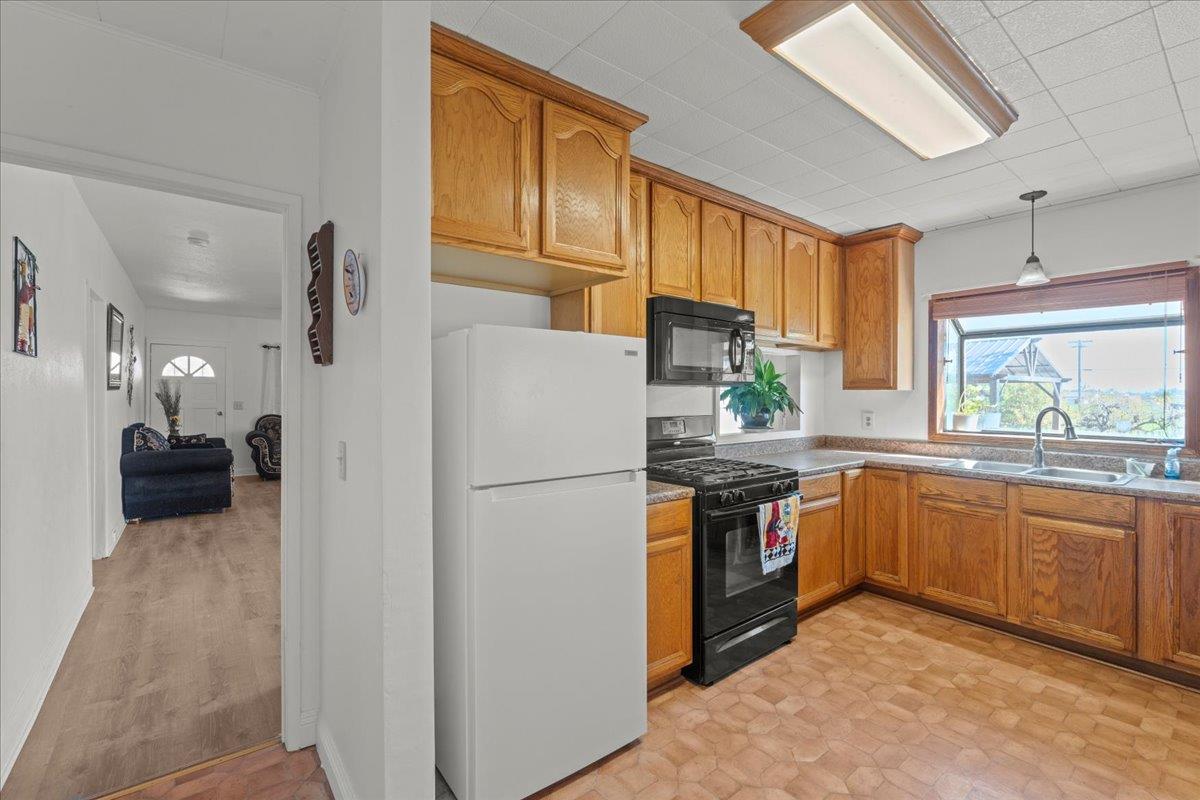 23707 North Graham Road Acampo, CA 95220 - Photo 12 of 37 a kitchen with stainless steel appliances granite countertop a refrigerator a stove a sink and a microwave
