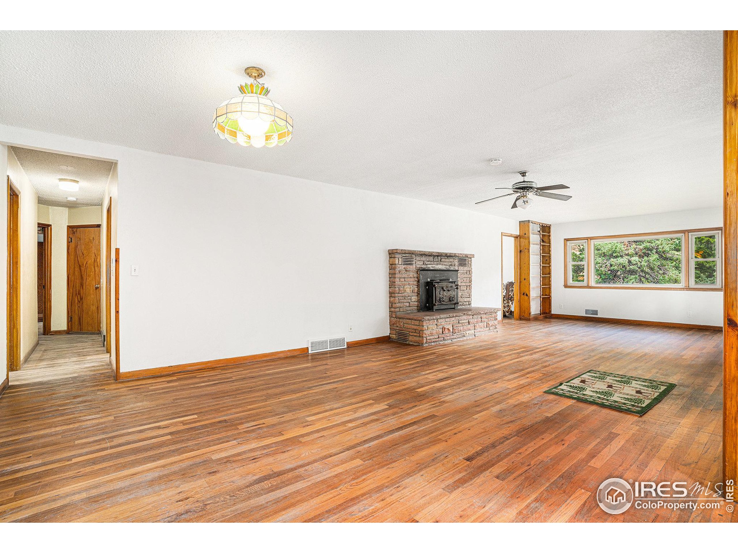 143 Waltonia Road Drake, CO 80515 - Photo 8 of 30 a view of an empty room with a window and wooden floor