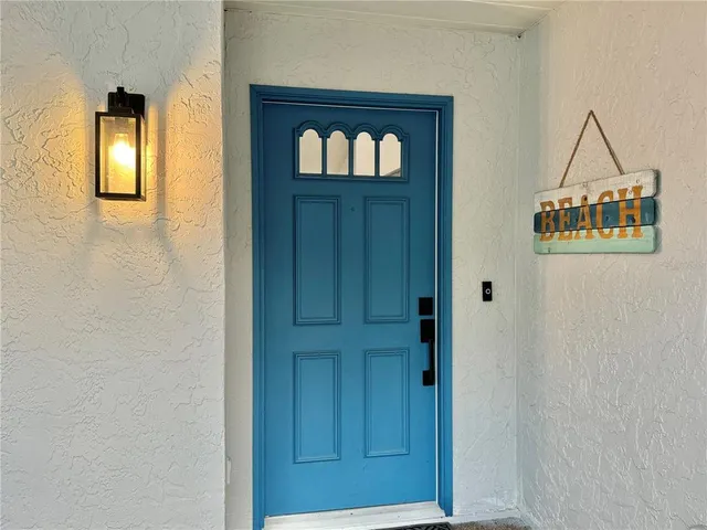 a large kitchen with a center island wooden floor stainless steel appliances and windows