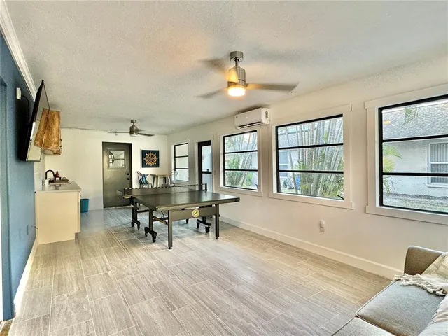 a living room with furniture a flat screen tv and wooden floor