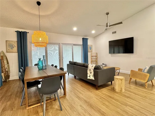 a kitchen with stainless steel appliances a dining table chairs sink and living room view